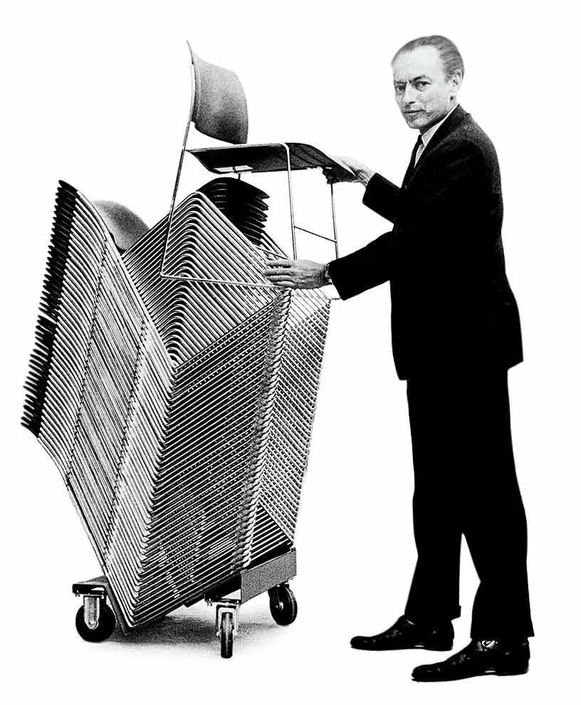 David Rowland standing beside stacked 40/4 chairs